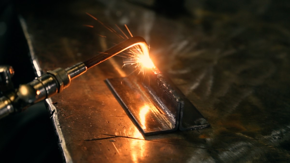 Welding steel with a torch.